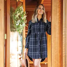 Woman standing in doorway wearing blue Celeste dress.